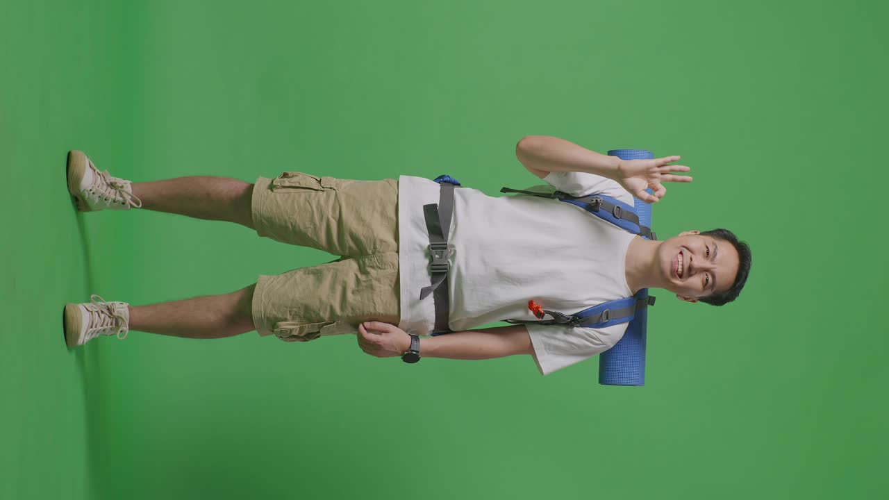 hombre con mochila dando la señal de ok en la pantalla verde