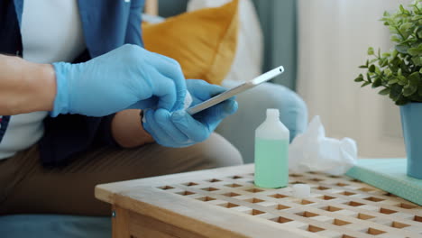 cleaning a phone with gloves and sanitizer