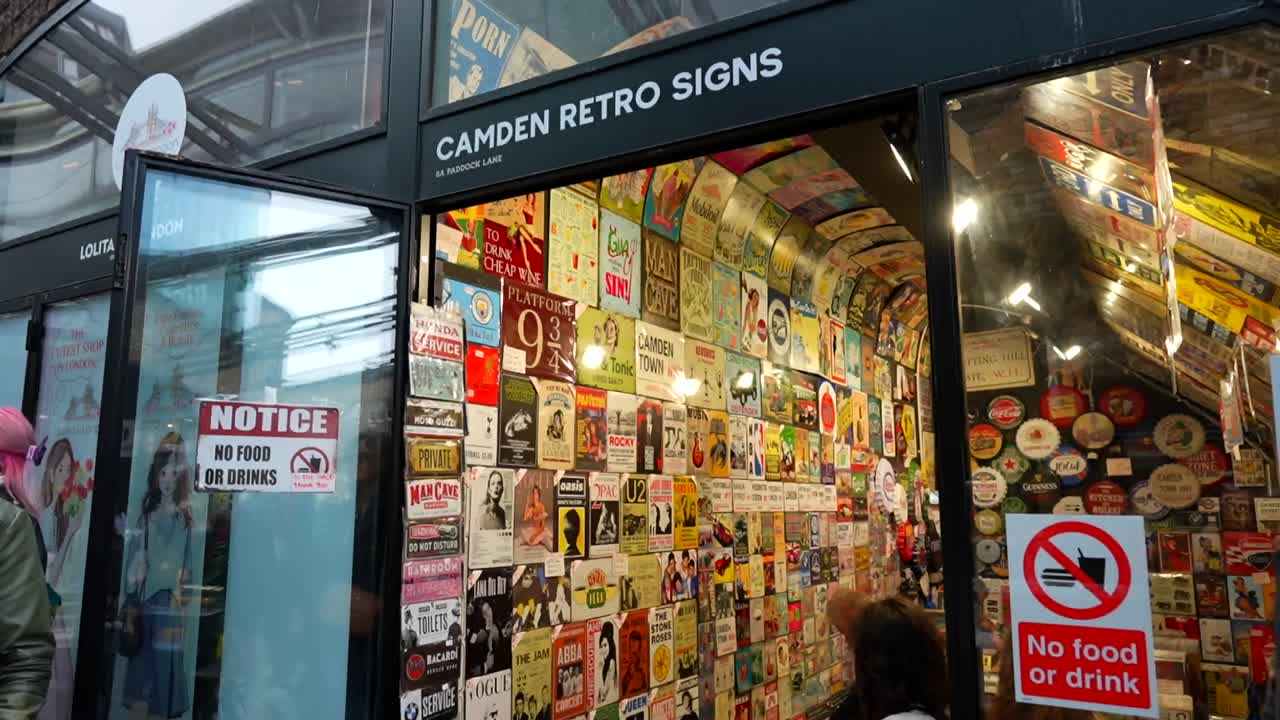 Retro sign shop in Camden Market, London with "no food or drink" signs and colorful vintage posters