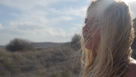 close-up of a woman in a white dress walking through a desert on a sunny day