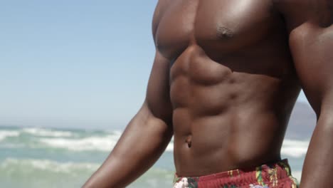 hombre caminando por la playa bajo el sol 4k