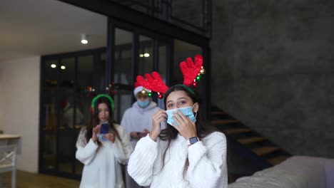 friends celebrating christmas while wearing masks