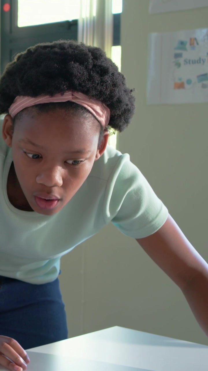 Vertical video: VR activating, boy leaning, mint girl heading class desk, adjusting tablet to share