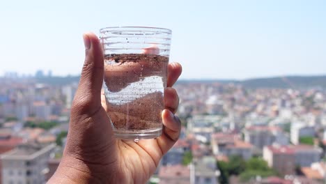 dirty water in a glass with city view