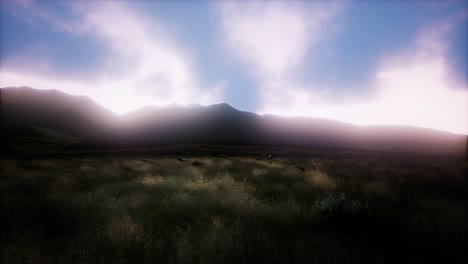 puesta de sol sobre unas colinas rocosas de hierba verde