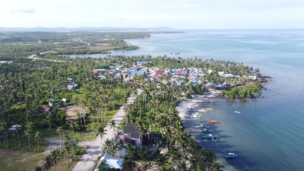 carretera tropical costera a lo largo de las aldeas pesqueras costeras en la isla de siargao, aérea