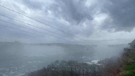 tirolesa de las cataratas del niágara atravesando la niebla a lo largo del día brumoso del río niágara, ancho