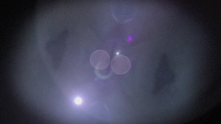 Animation of a kaleidoscope of white and pink spots of bokeh light moving in hypnotic motion in on a