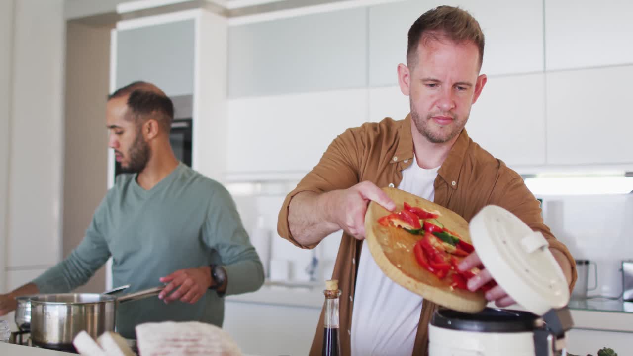 pareja multiétnica del mismo sexo preparando comida juntos en la cocina
