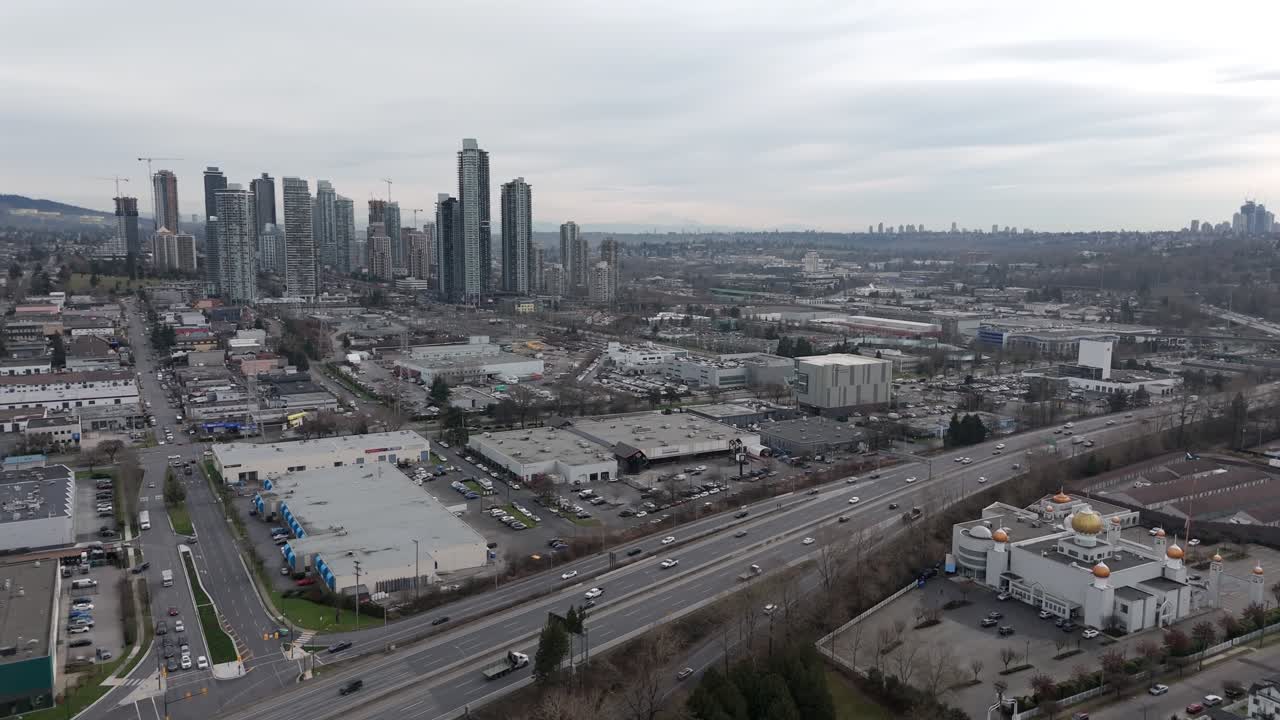 Vista aérea de la Autopista Transcanadiense y un Gurudwara en Vancouver, Canadá, con el horizonte de Burnaby a la distancia. Toma panorámica