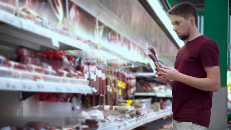 man shopping for sausage in a supermarket