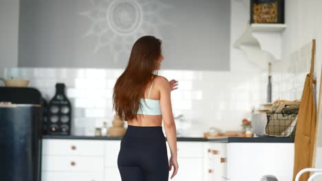 young woman in activewear in a kitchen