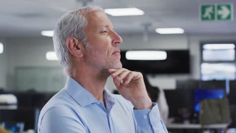 Thoughtful-man-rubbing-his-chin-in-office