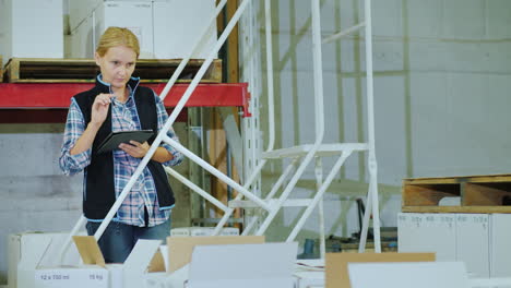 A-Woman-With-A-Tablet-Holds-Inventory-In-A-Warehouse