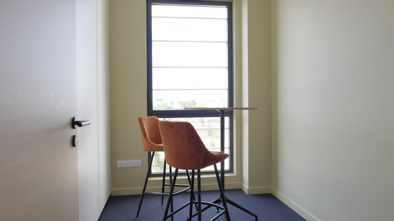 slow establishing shot of a high table at a window within an office