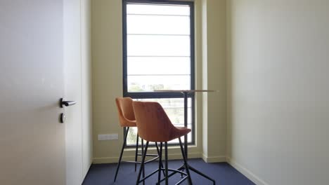 slow establishing shot of a high table at a window within an office