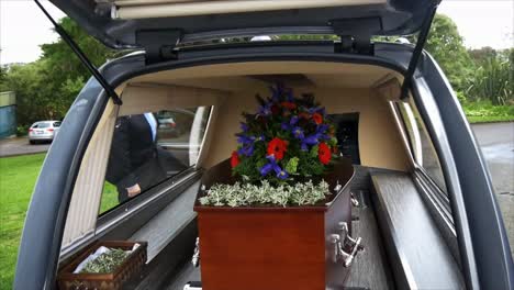 closeup shot of a funeral casket in a hearse or chapel or burial at cemetery