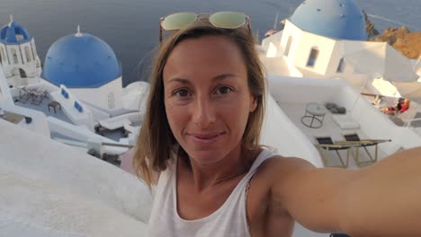 slow motion: young woman in santorini greece taking selfie