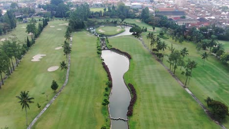 luxury golf course with water pond in magelang, indonesia, aerial drone view