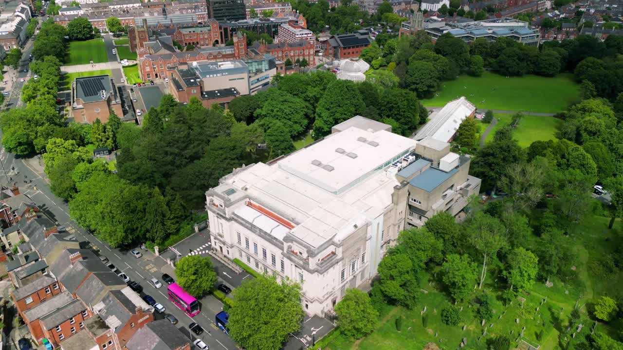 Side-on rotating aerial video of Ulster Museum in Botanic Gardens in Belfast, Northern Ireland on a bright sunny day. Produced in 4K, 30 frames per second and with Rec709 color.
