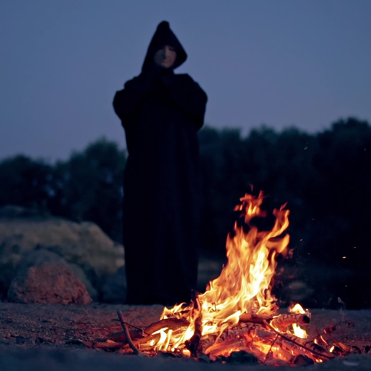 Sad monk by the fire