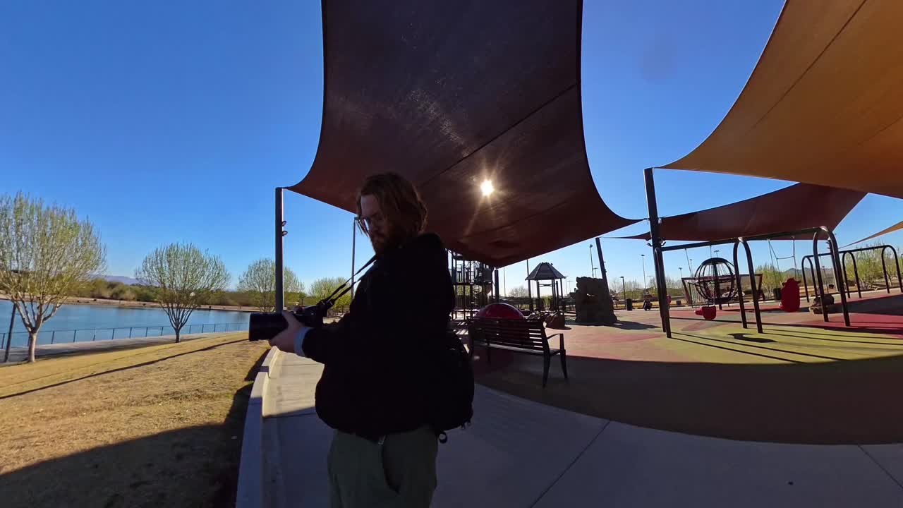 Static Red haired male taking pictures by playground in Mansel Crater Park in Queen Creek Arizona.