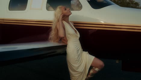 woman in a cream dress by a private jet