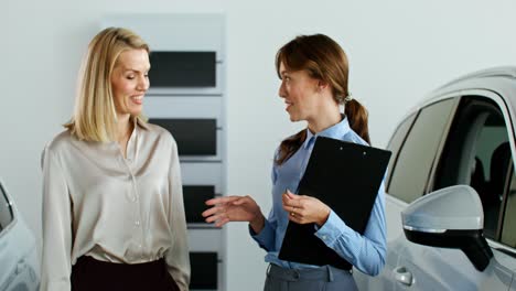 woman discussing car purchase with sales representative