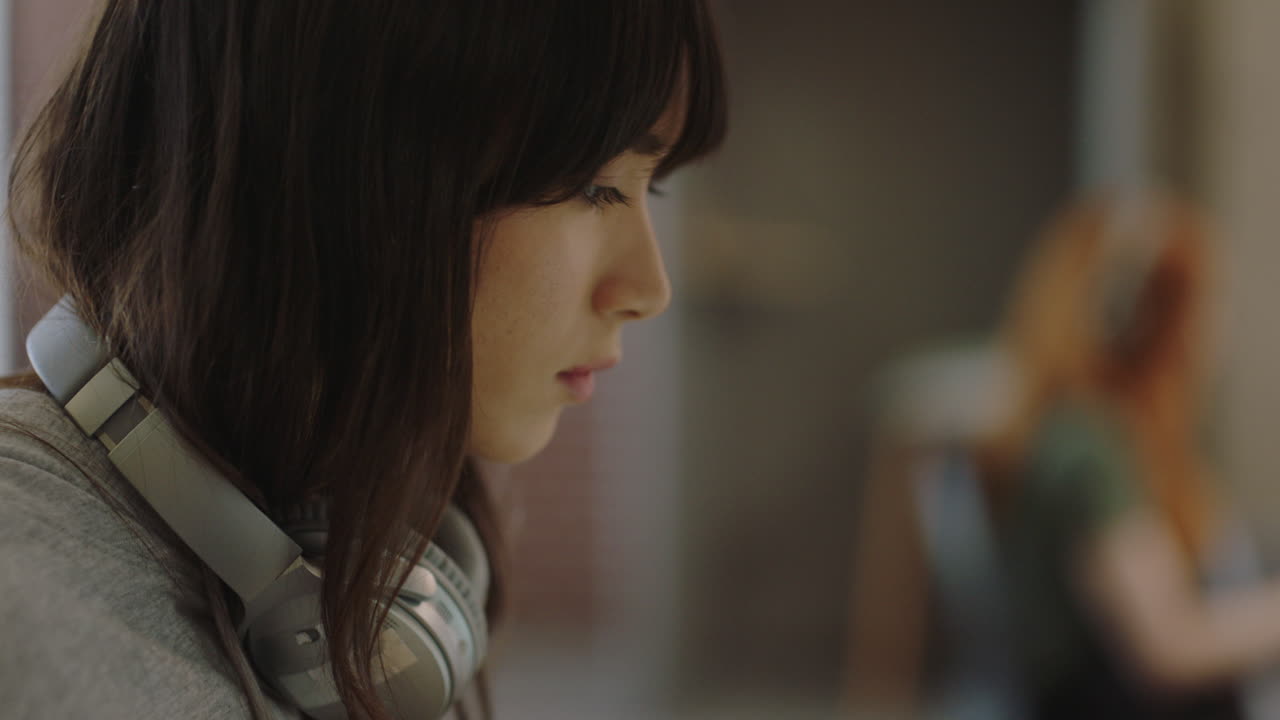 젊은 아시아 사업가 여성이 노트북 컴퓨터를 사용하여 프로젝트를 진행하고 주스를 마시고 바쁜 사무실에서 창의적인 프로젝트를 즐기고 있습니다.