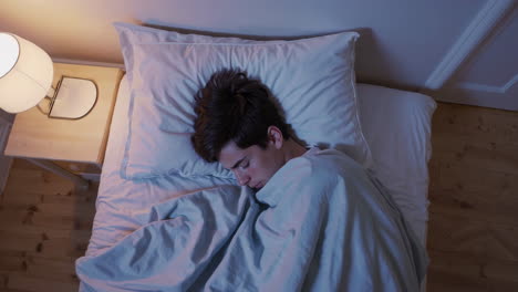young person sleeping peacefully in bed at night