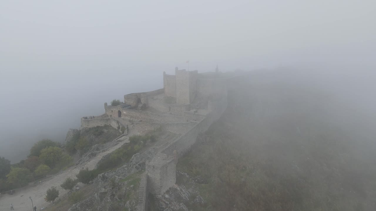 panorámica lenta alrededor de los muros del castillo desapareciendo en la niebla alrededor del castillo de marvão