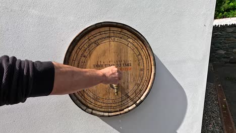 hand using tap on whisky barrel