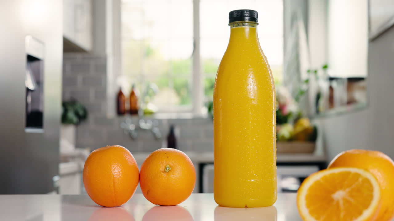 Fresh Orange Juice Bottle and Oranges on a Kitchen Counter