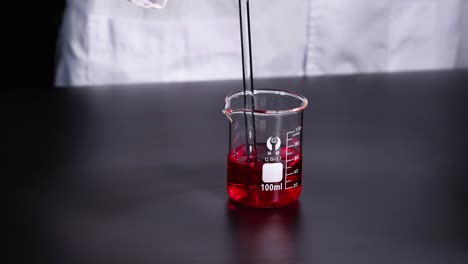 scientist pouring liquid into beaker