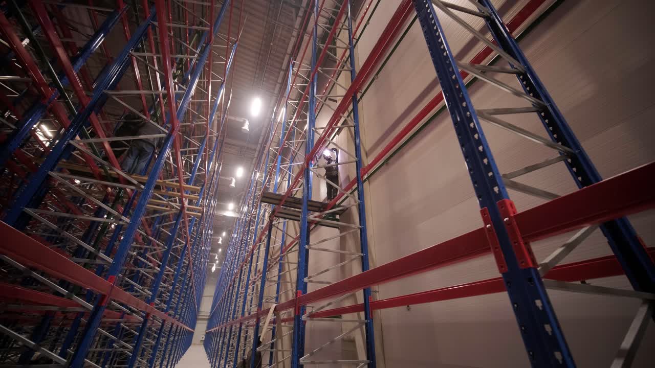 Big and modern warehouse under construction, featuring metal shelving and other industrial equipment.