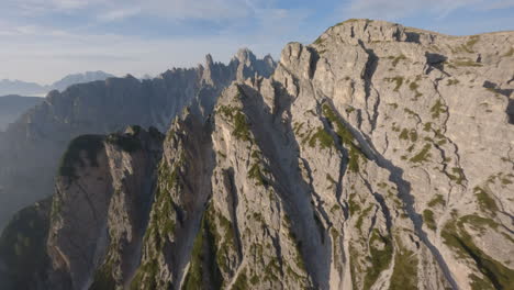 drone flying towards high rocky peaks of dolomites mountain range in summer season