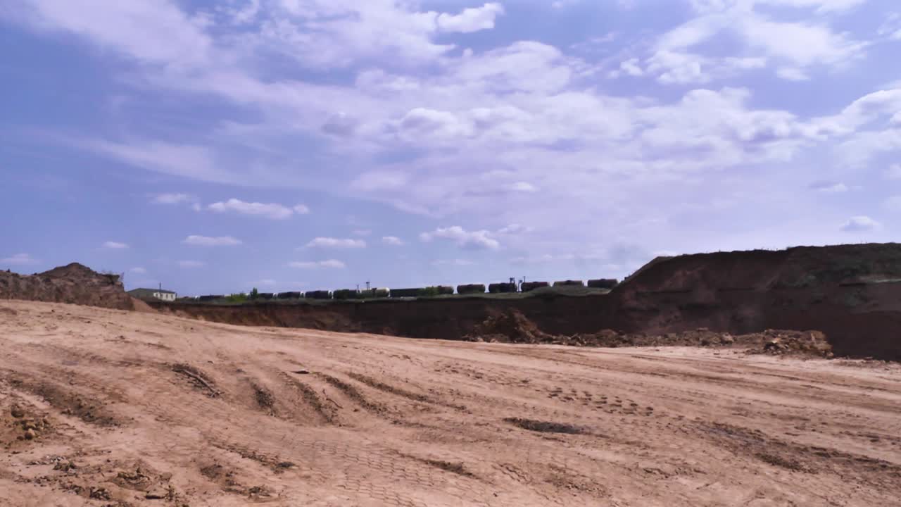 Cava a cielo aperto con treno sullo sfondo