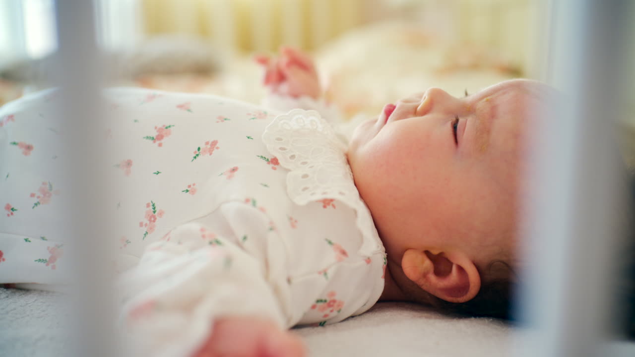 Genitore che accarezza dolcemente il bambino sdraiato nella culla in una calda luce naturale