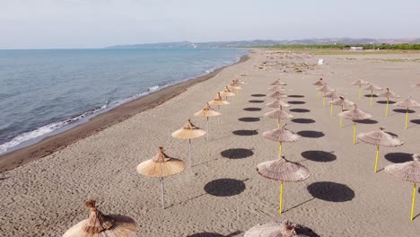 Sombrillas-Y-Mujer-Solitaria-En-La-Playa-De-Arena-En-Albania-Durante-La-Temporada-De-Verano