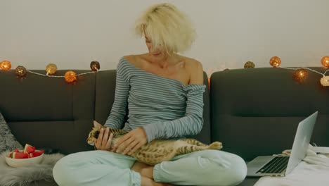 woman relaxing with her cat on a sofa
