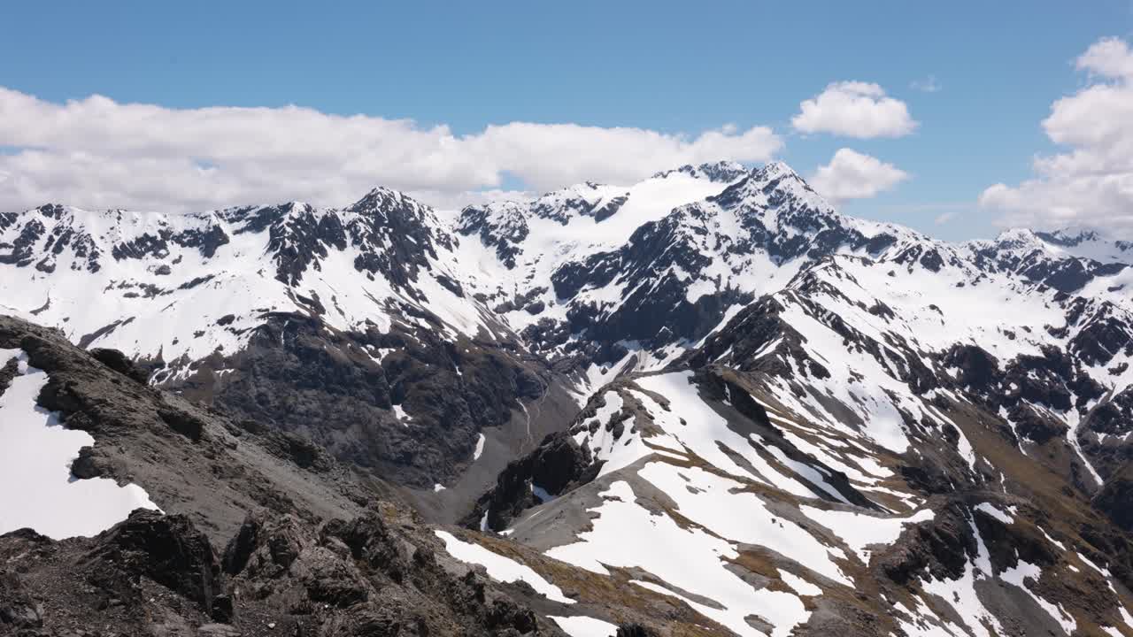 View of snow covered mountains and peak on a sunny summer day at Avalanche Peak, Arthur's Pass, New Zealand.