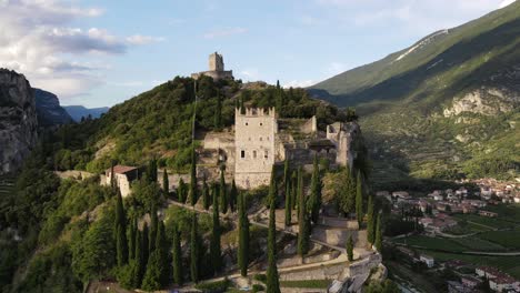 revealing drone shot of a castle on a mountain near lake garda, italy