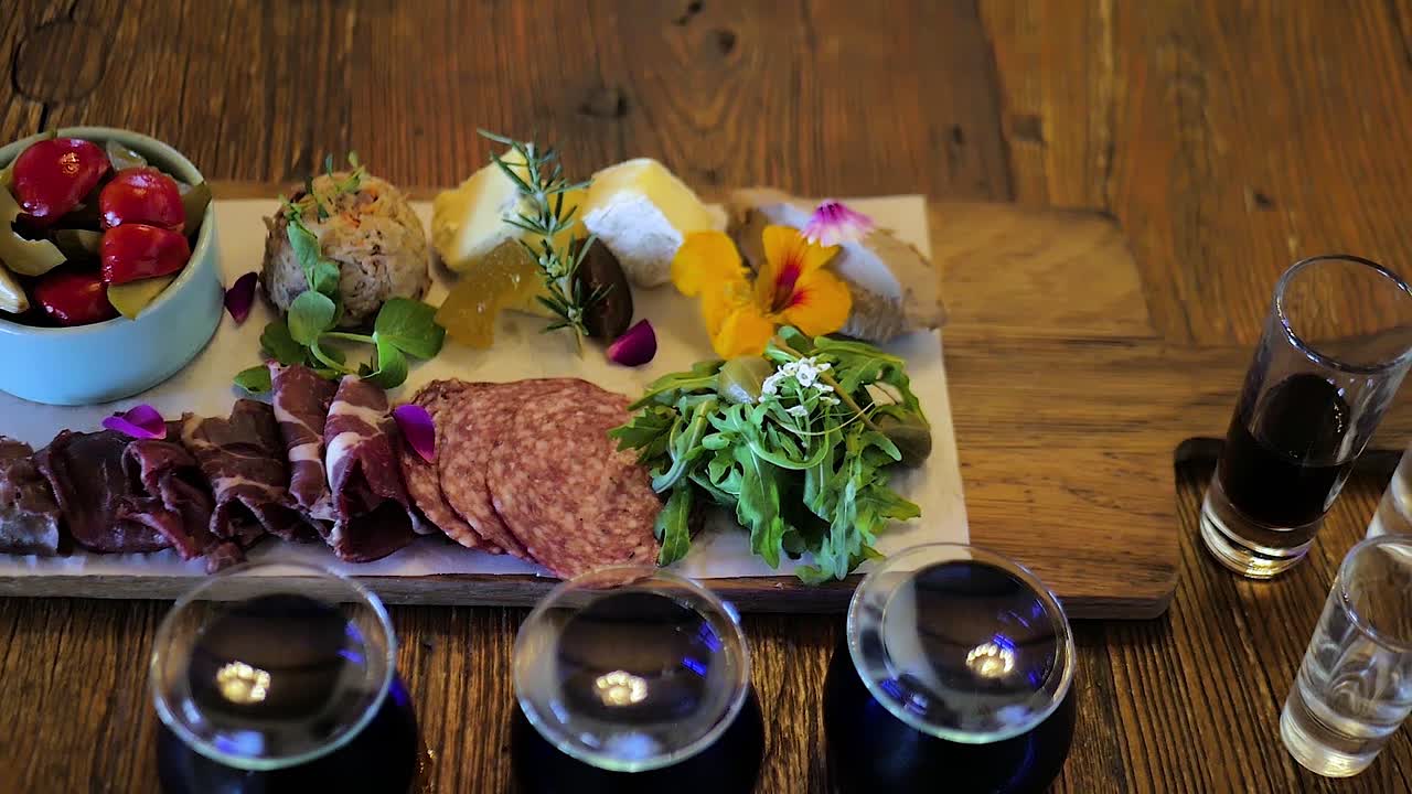 plato de embutidos y queso junto con chupitos de grappa