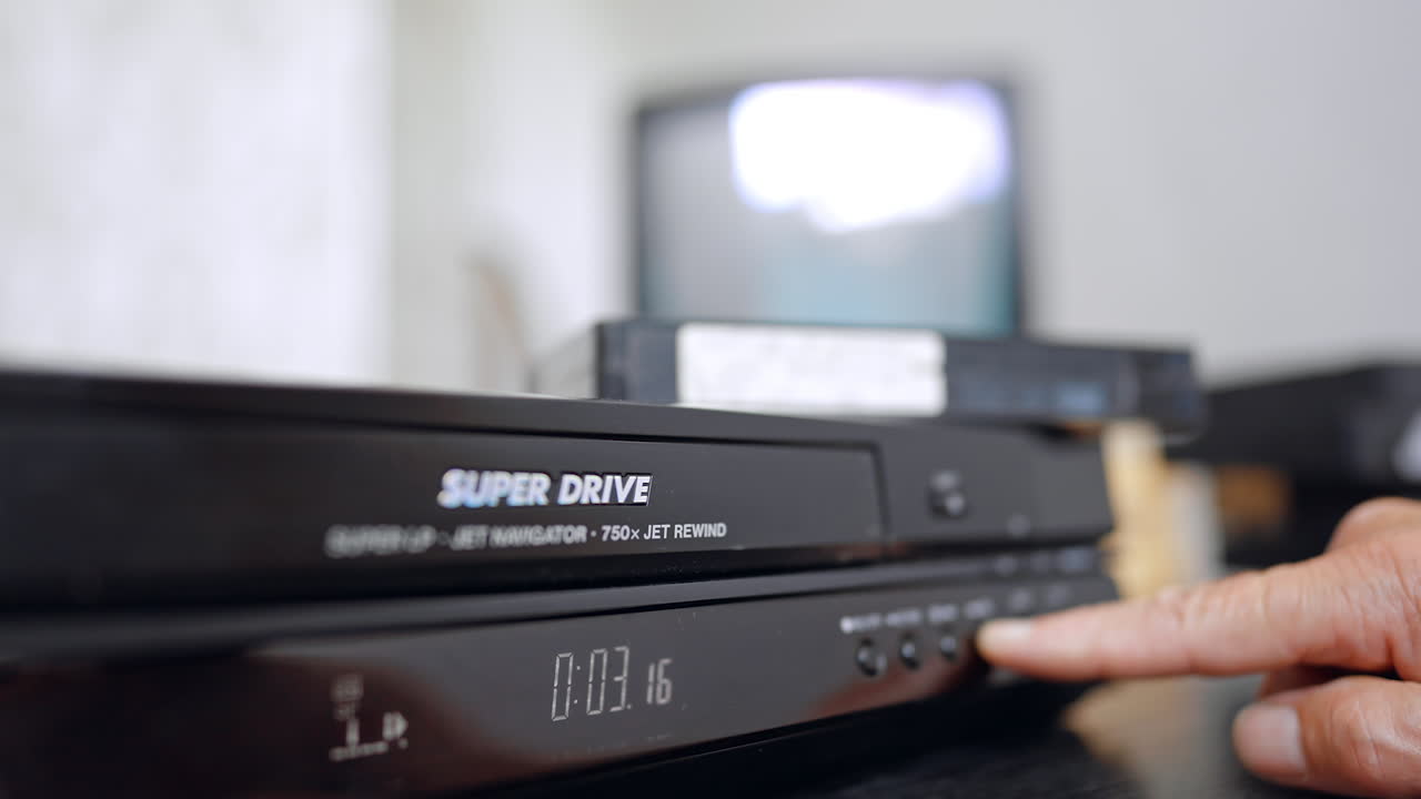 Male hand presses the button on the player. Close up. Old-style screen works at backdrop in blur