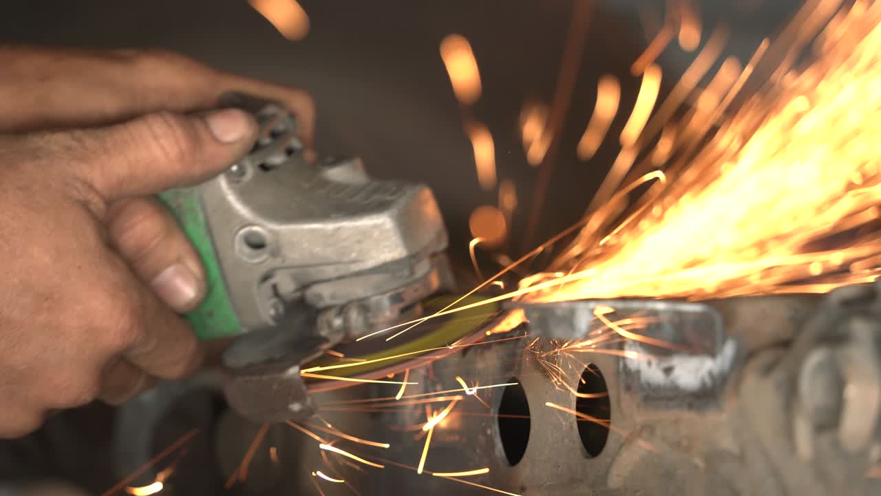 trabajador metalúrgico moliendo en un taller de reparación de carrocerías de automóviles, primer plano