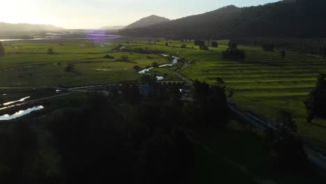 Tilting-Up-Aerial-Shot-Of-A-Green-Valley-Of-Farms-And-Farmland-In-The-South-Island-Of-New-Zealand