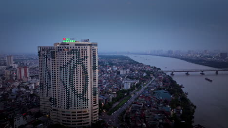 urban riverfront residential apartment buildings in hanoi city at night, establishing shot