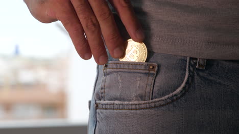 un hombre de pie y poniendo un bitcoin en