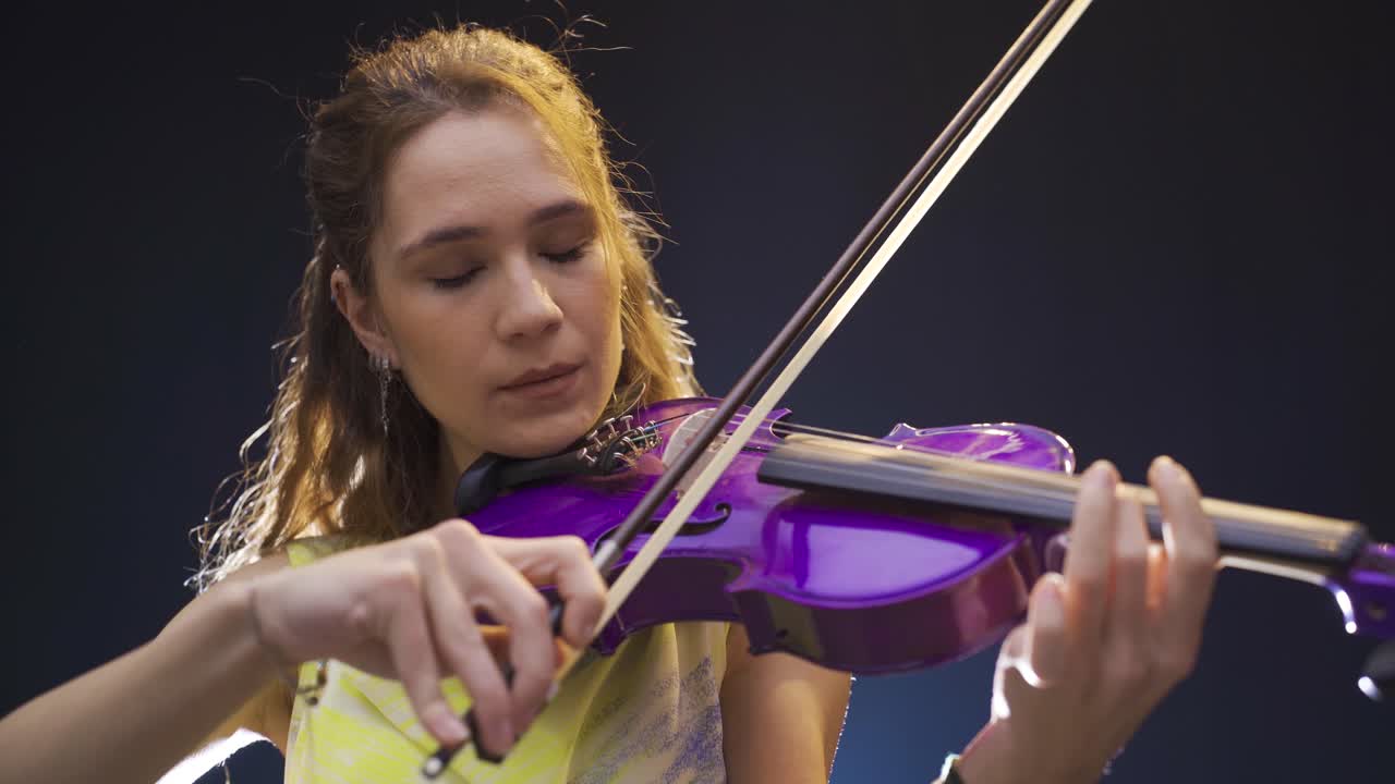 una joven violinista tocando el violín.