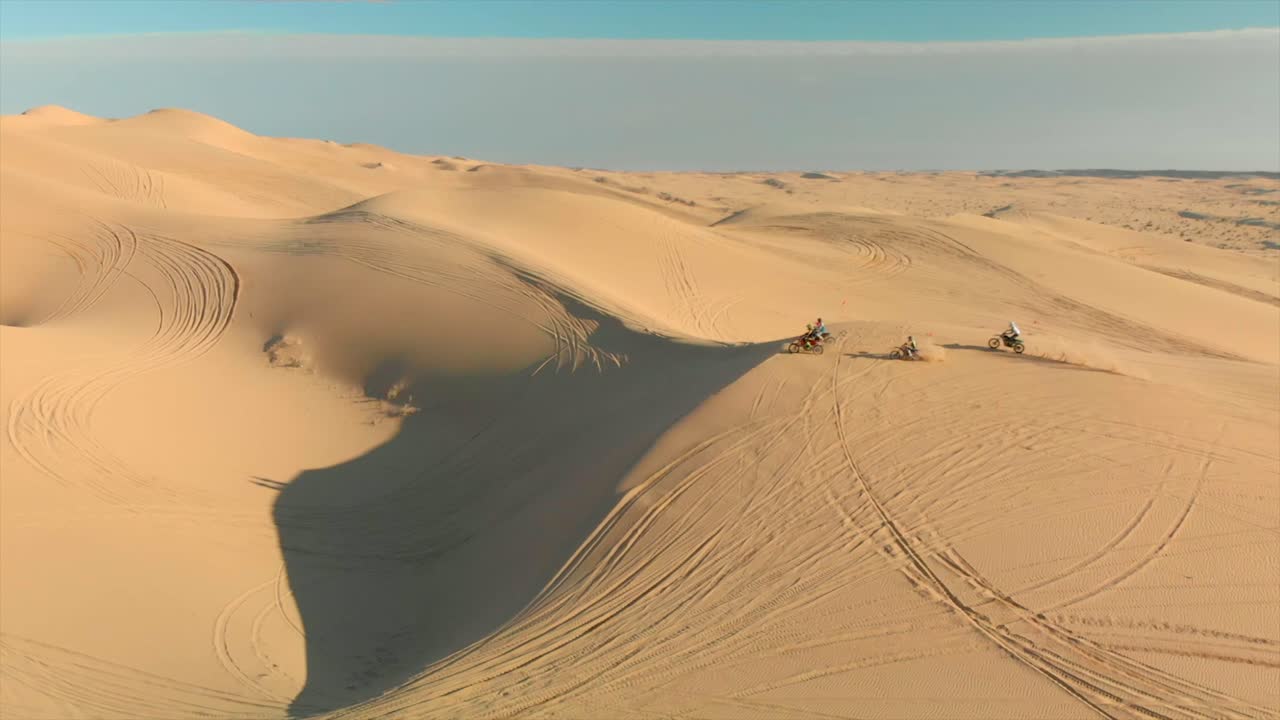 antena de dunas de arena del desierto con motocross y un hombre corriendo
